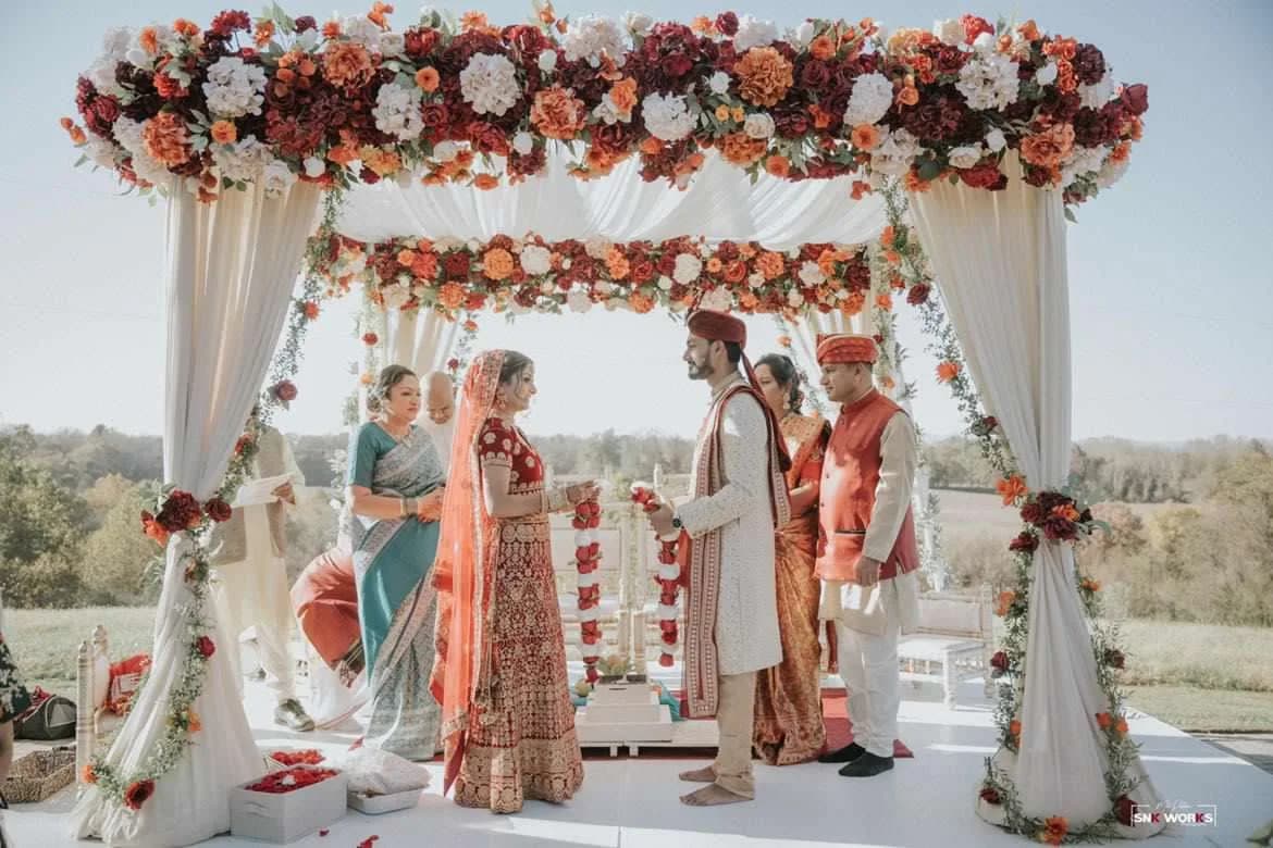 Indian wedding ceremony under a floral mandap at Rixey Manor, rolling hills in the background