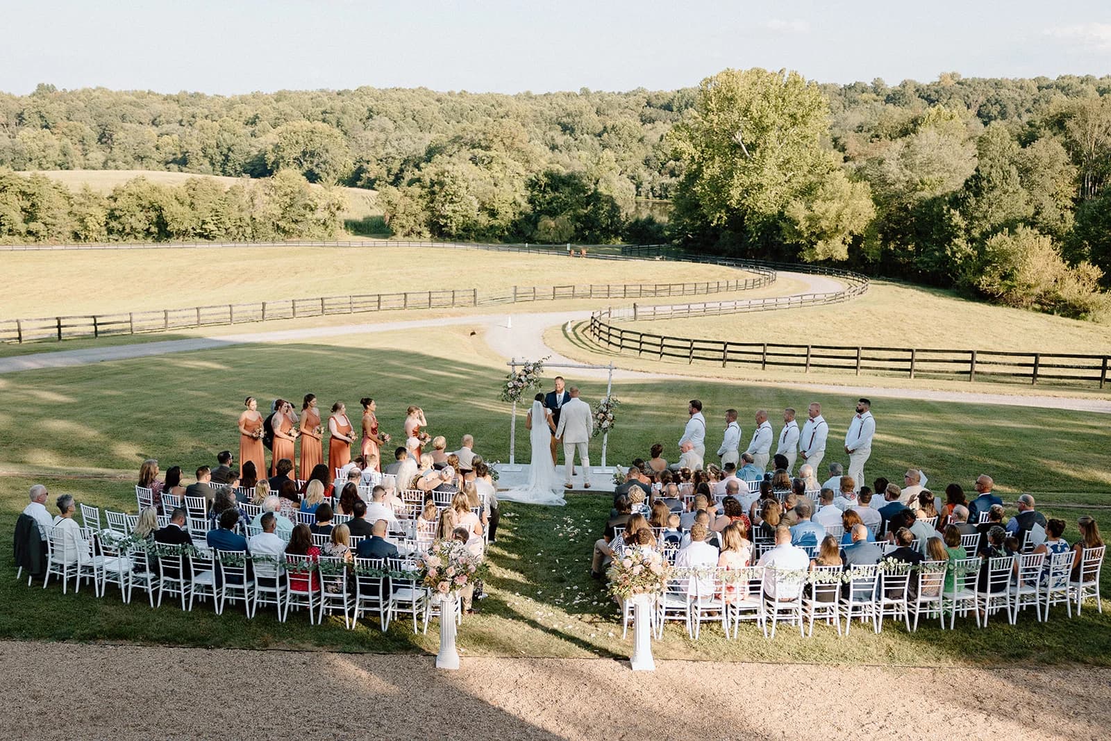 Groom lifts his bride into a kiss on the dance floor under a canopy of hanging wisteria inside the reception tent