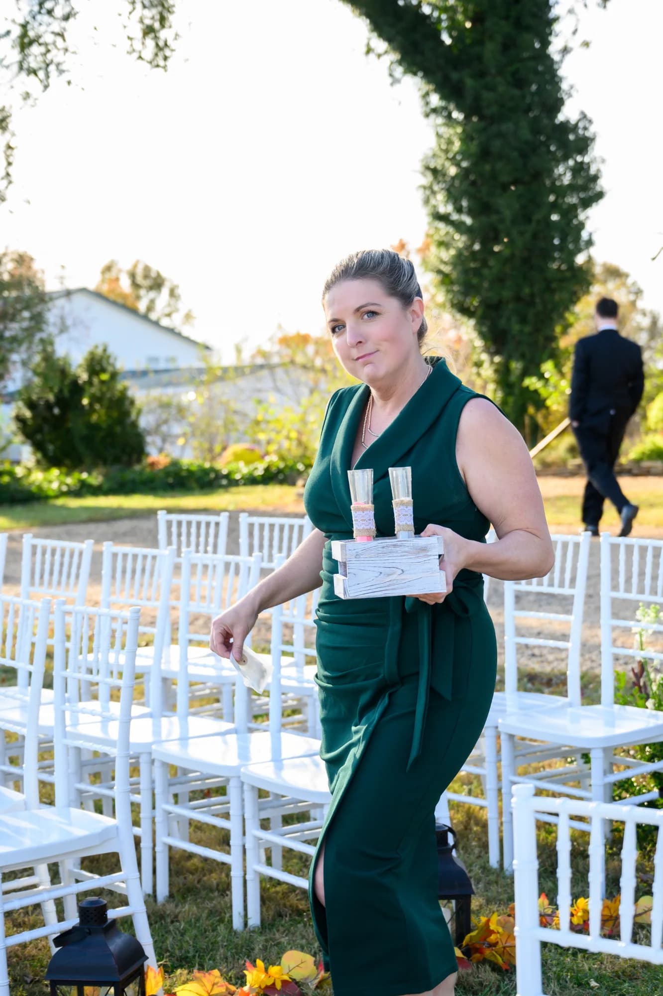 Isadora Martin-Dye, owner of Rixey Manor, at the ceremony altar with autumn foliage and the lake behind her