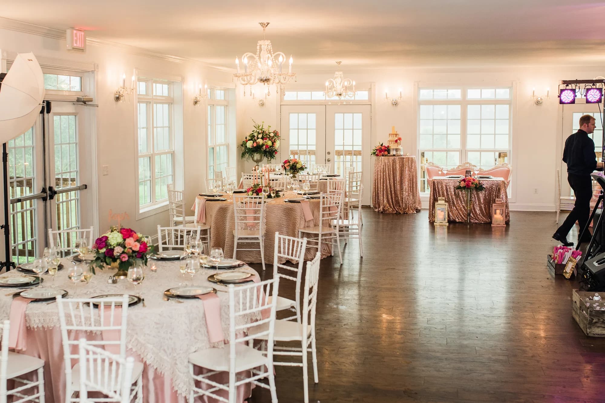 Elegant blush and gold reception setup in Rixey Manor ballroom with crystal chandeliers and floral centerpieces