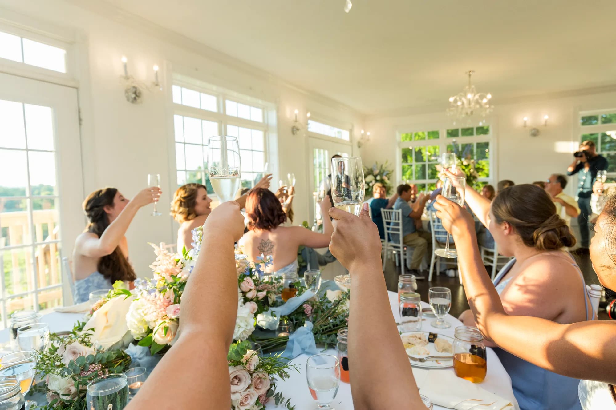 Wedding reception toast at Rixey Manor with guests raising glasses in elegant bright venue