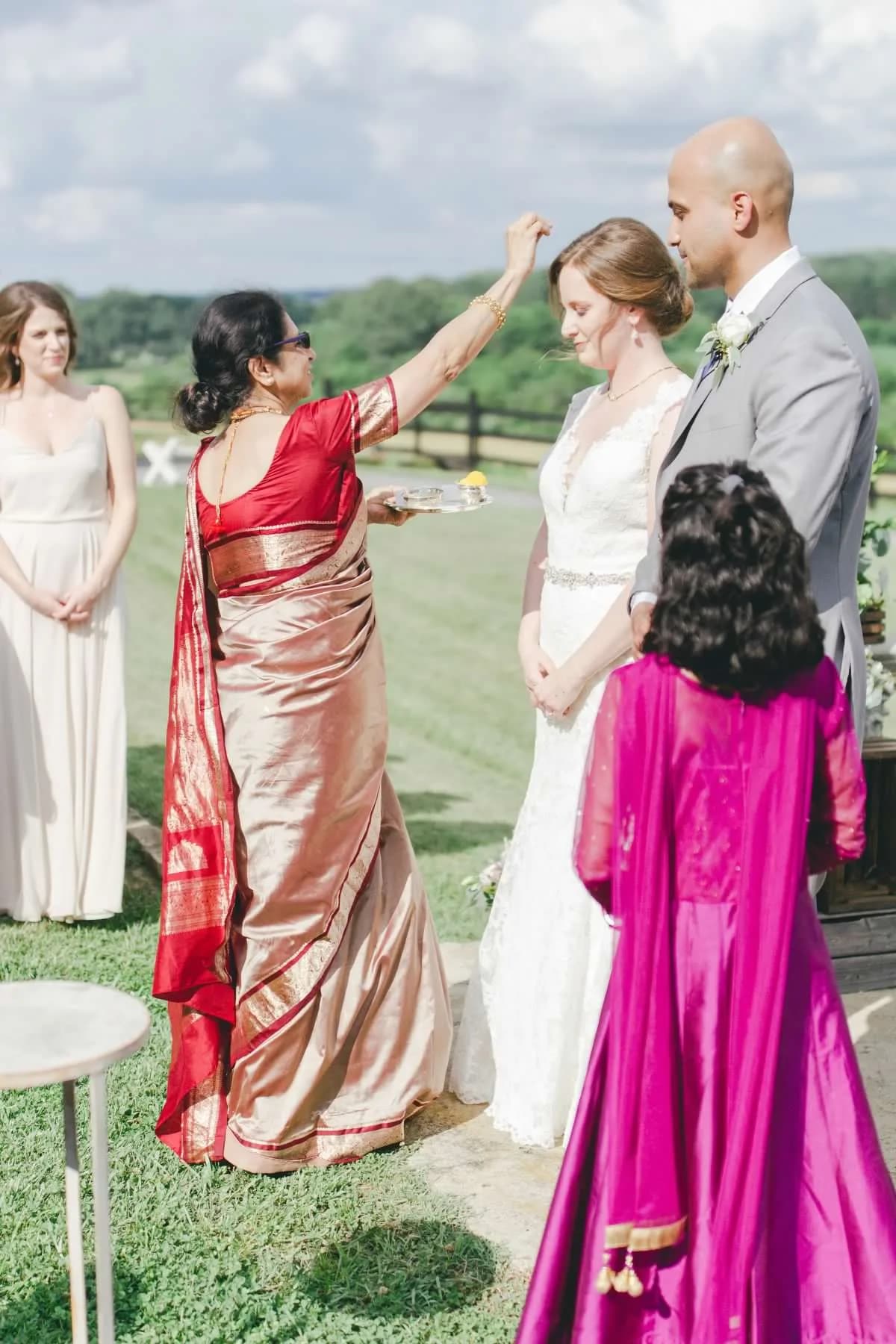 Indian mother applies sindoor to bride during outdoor fusion wedding ceremony at Rixey Manor