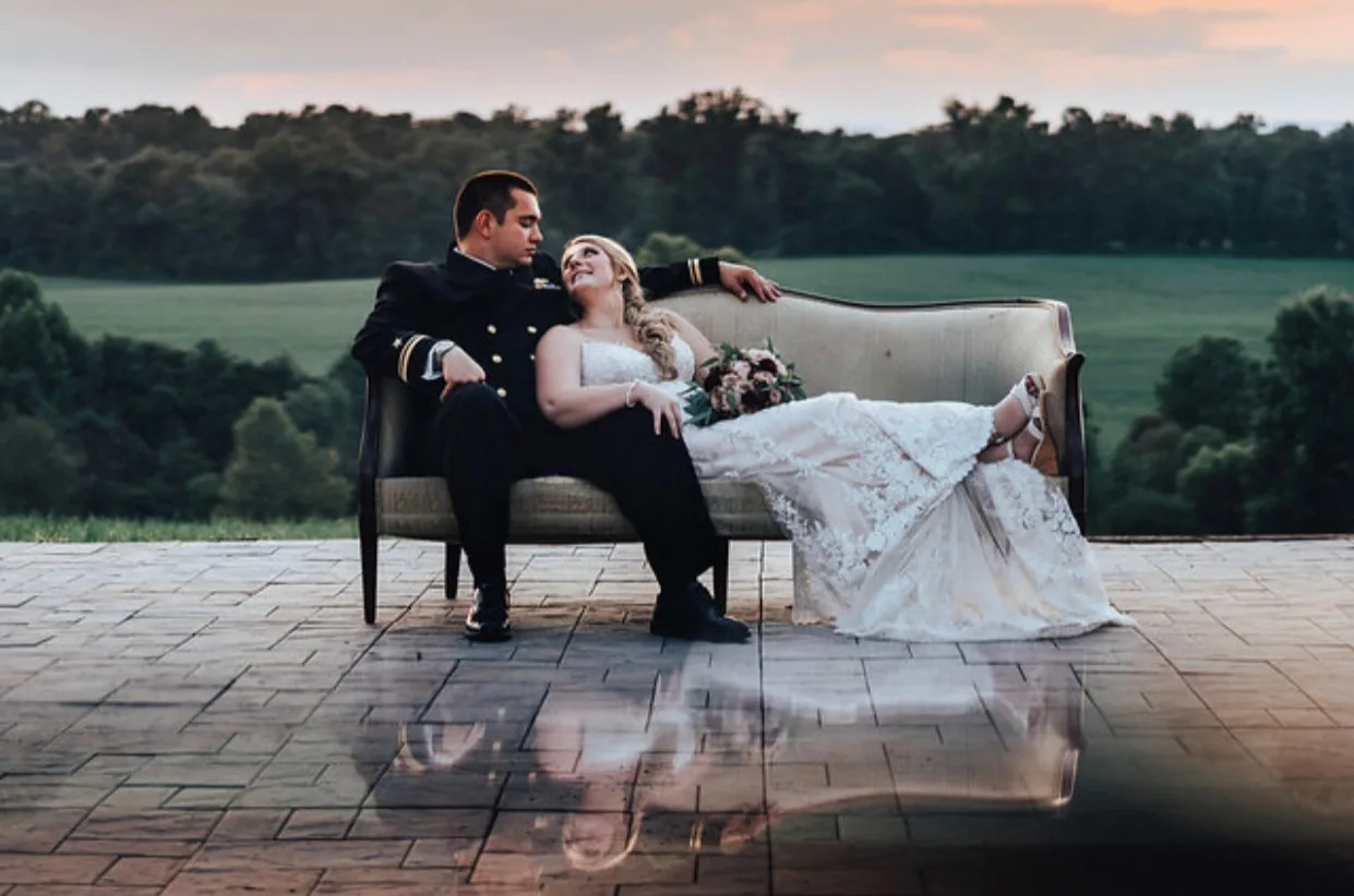 Newlyweds share an intimate moment on a vintage sofa on Rixey Manor's terrace at golden hour