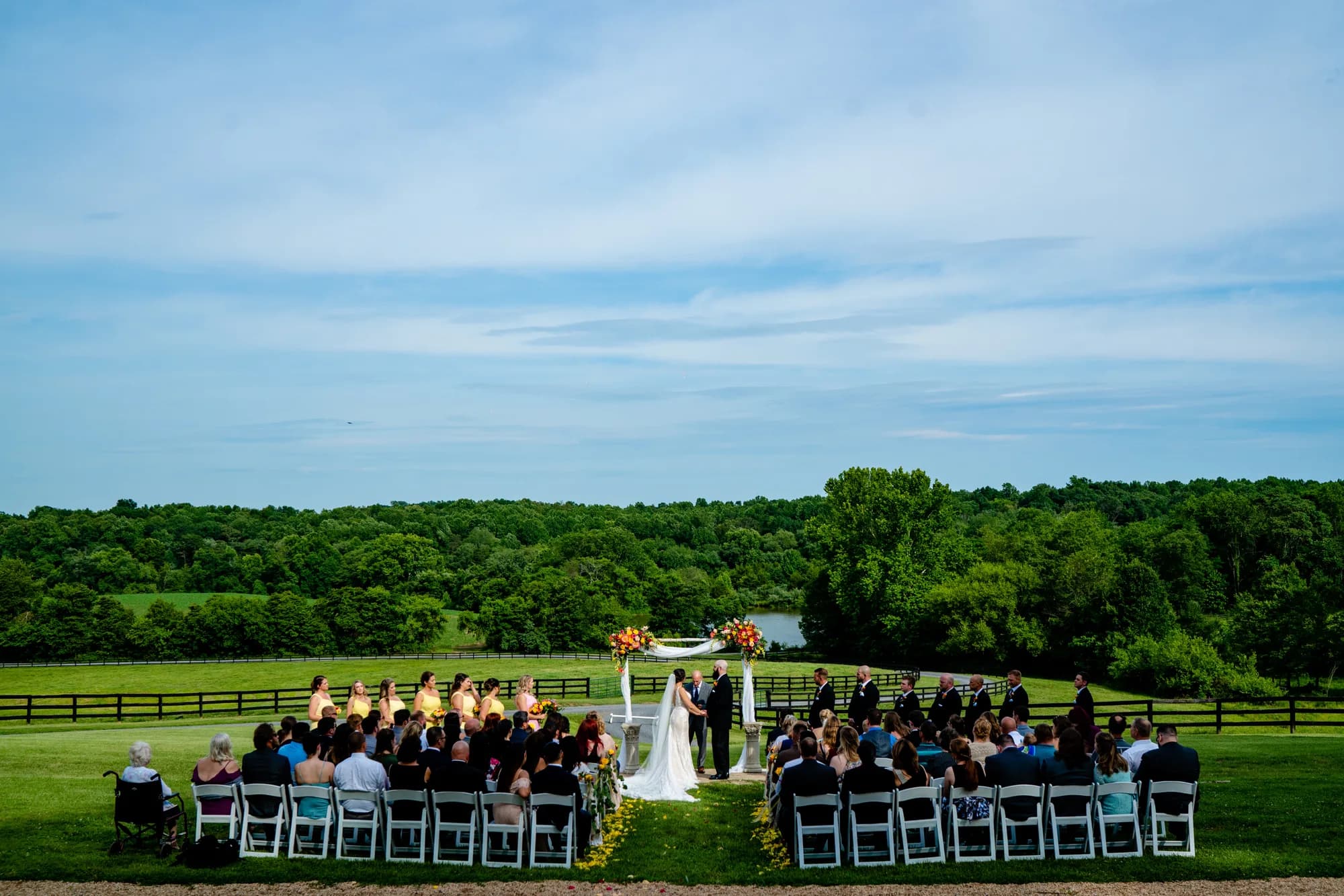Aerial view of outdoor wedding ceremony at Rixey Manor with rolling Virginia hills, lake, and lush forest backdrop