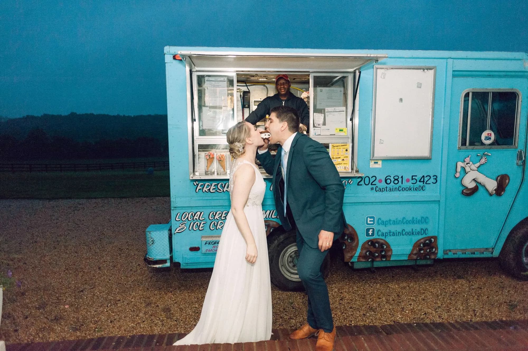 Bride and groom share a kiss in front of a teal Captain Cookie DC ice cream truck at twilight