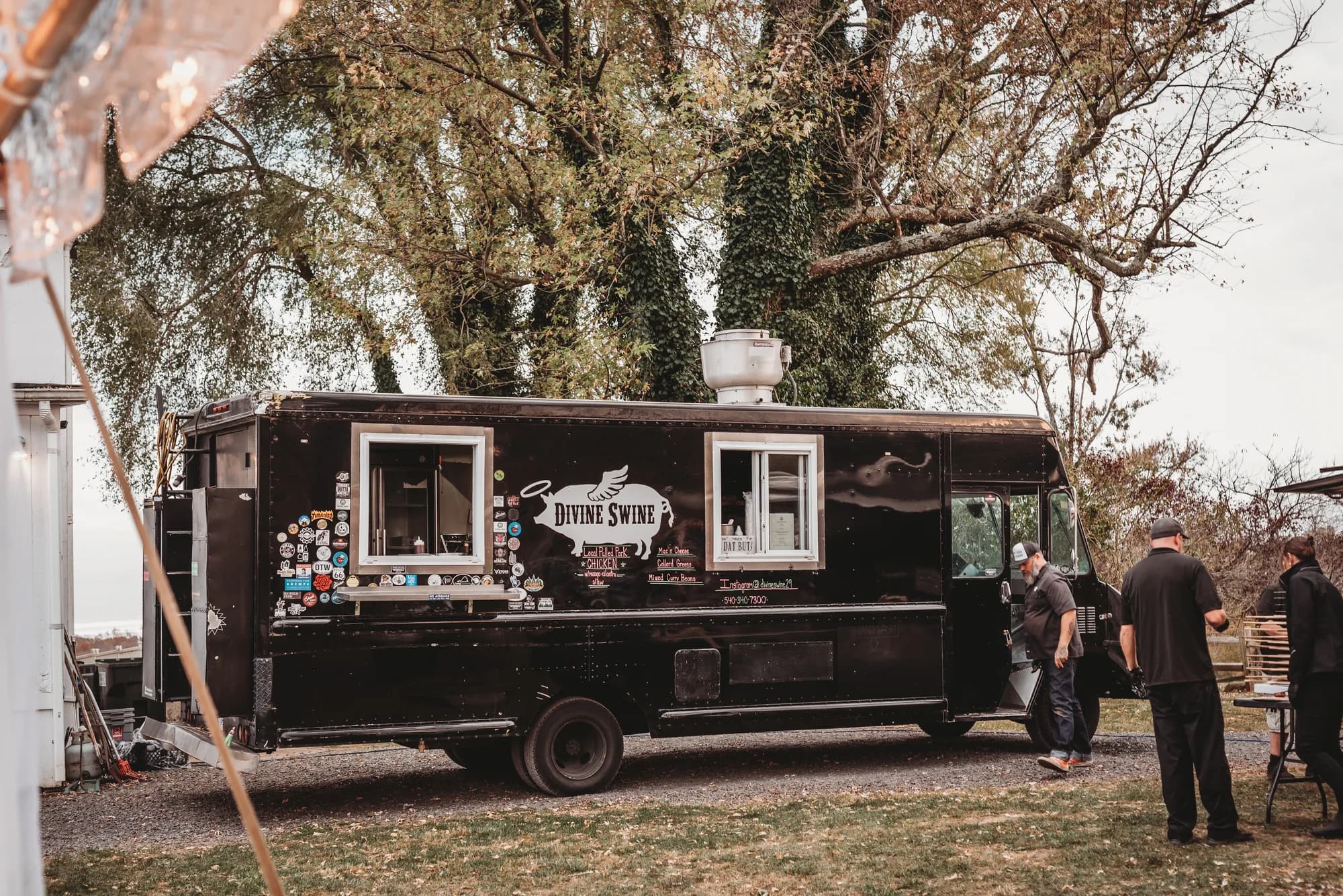 Black food truck at Rixey Manor wedding venue with guests in formal attire nearby
