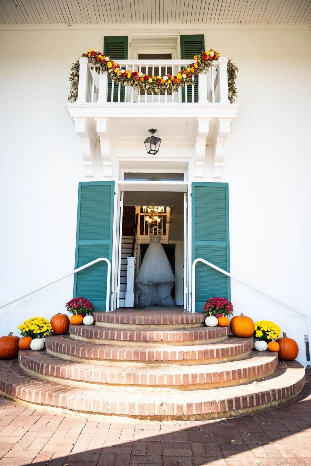Rixey Manor front entrance with fall pumpkins, mums, and bridal gown hanging in doorway