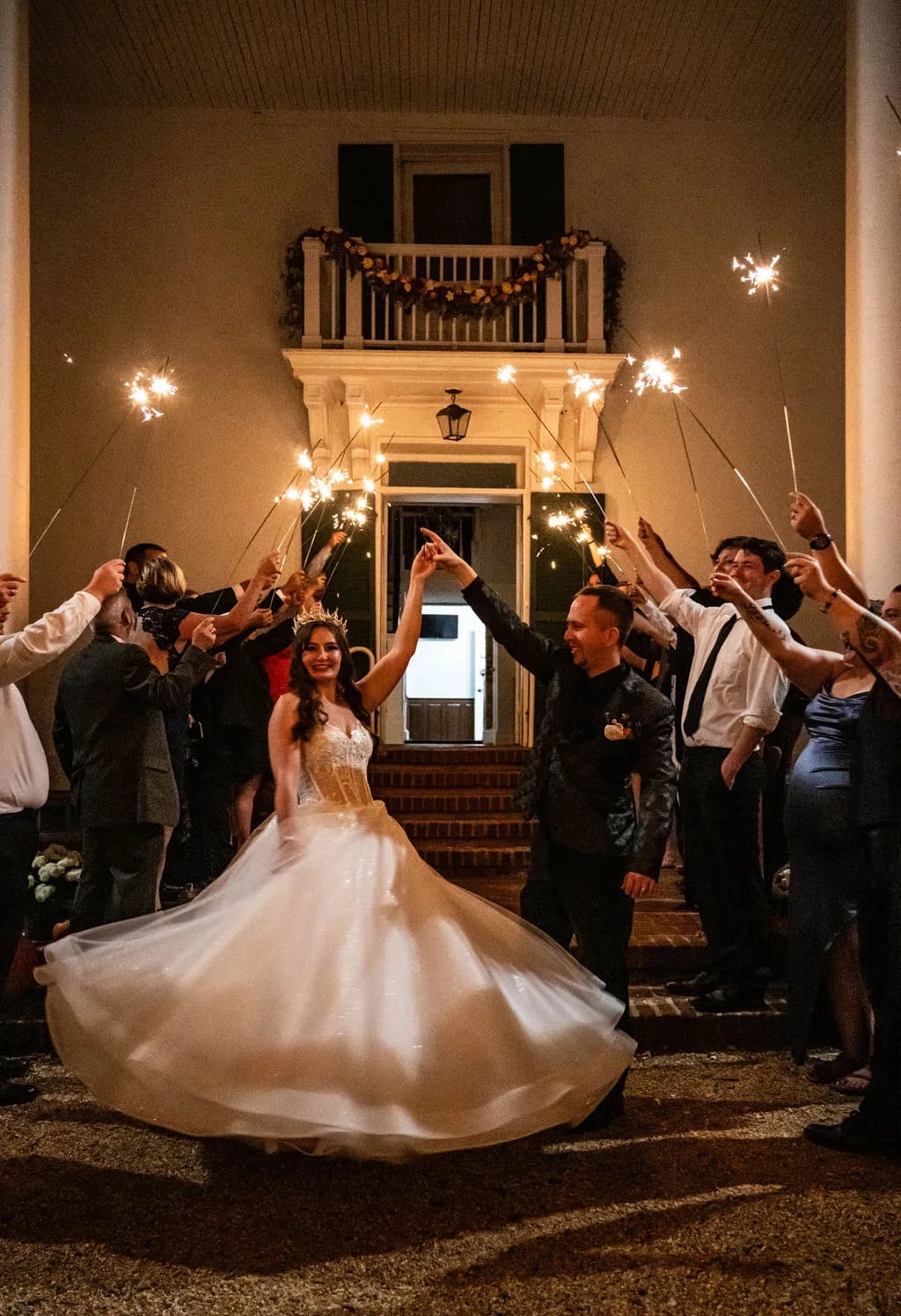 Bride twirls in ballgown during sparkler send-off outside Rixey Manor's historic columned entrance at night