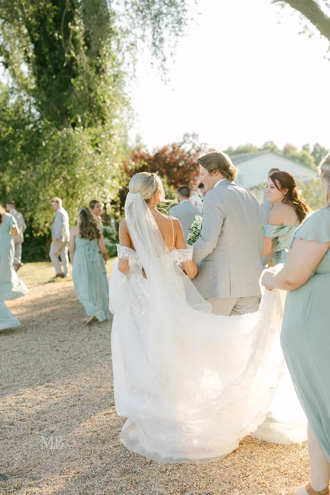 Bride and groom exchanging vows at outdoor wedding ceremony under willow tree at Rixey Manor
