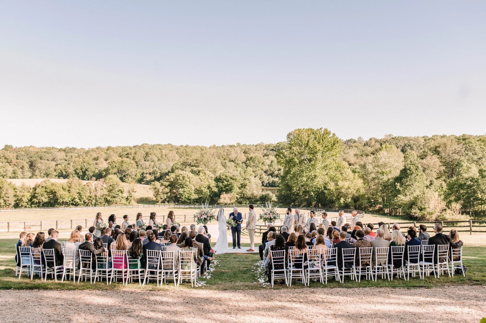 Aerial view of outdoor wedding ceremony at Rixey Manor with guests seated in semicircle amid rolling Virginia countryside