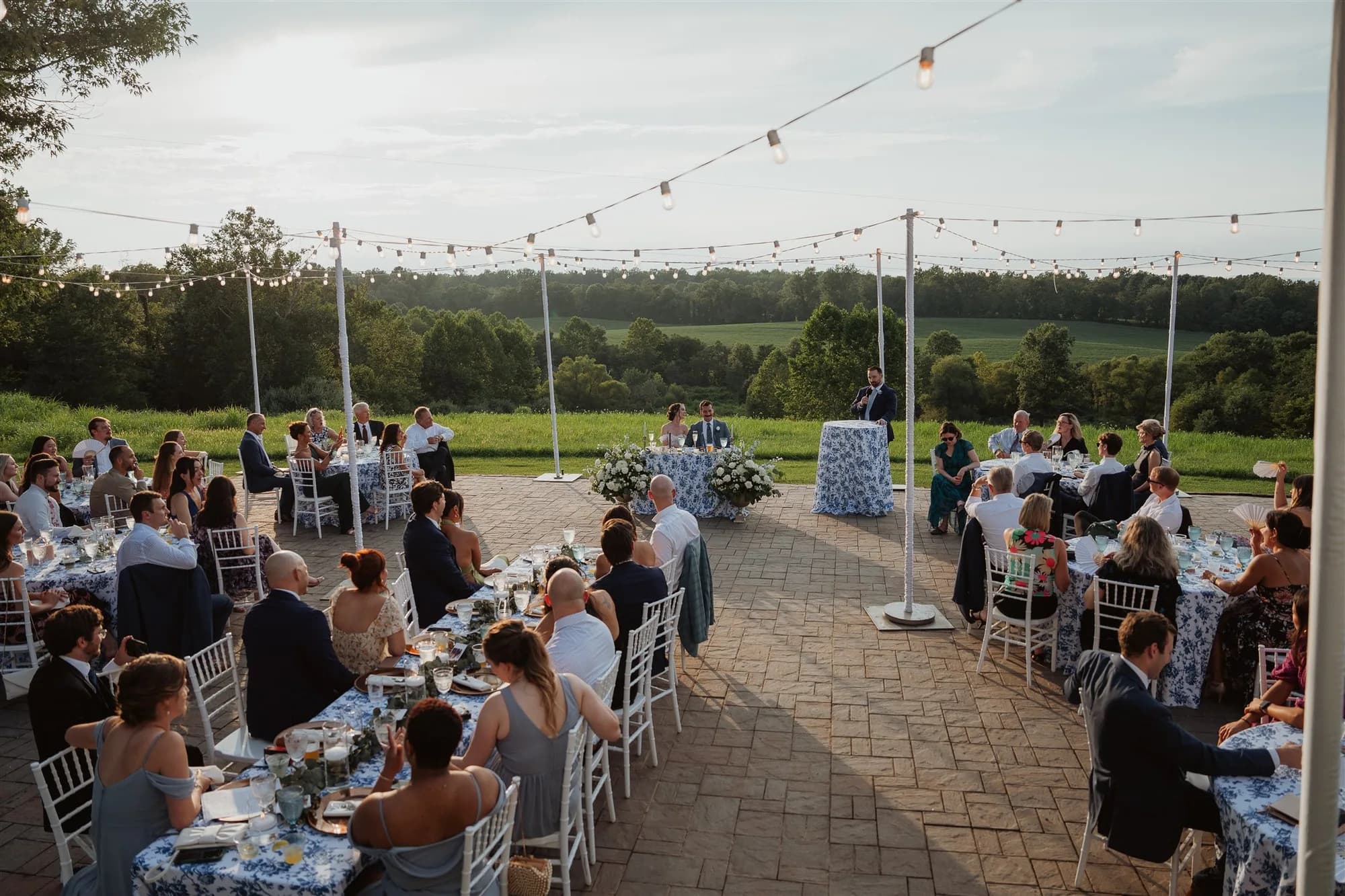 Outdoor wedding reception at Rixey Manor with guests seated at tables under string lights in rural Virginia