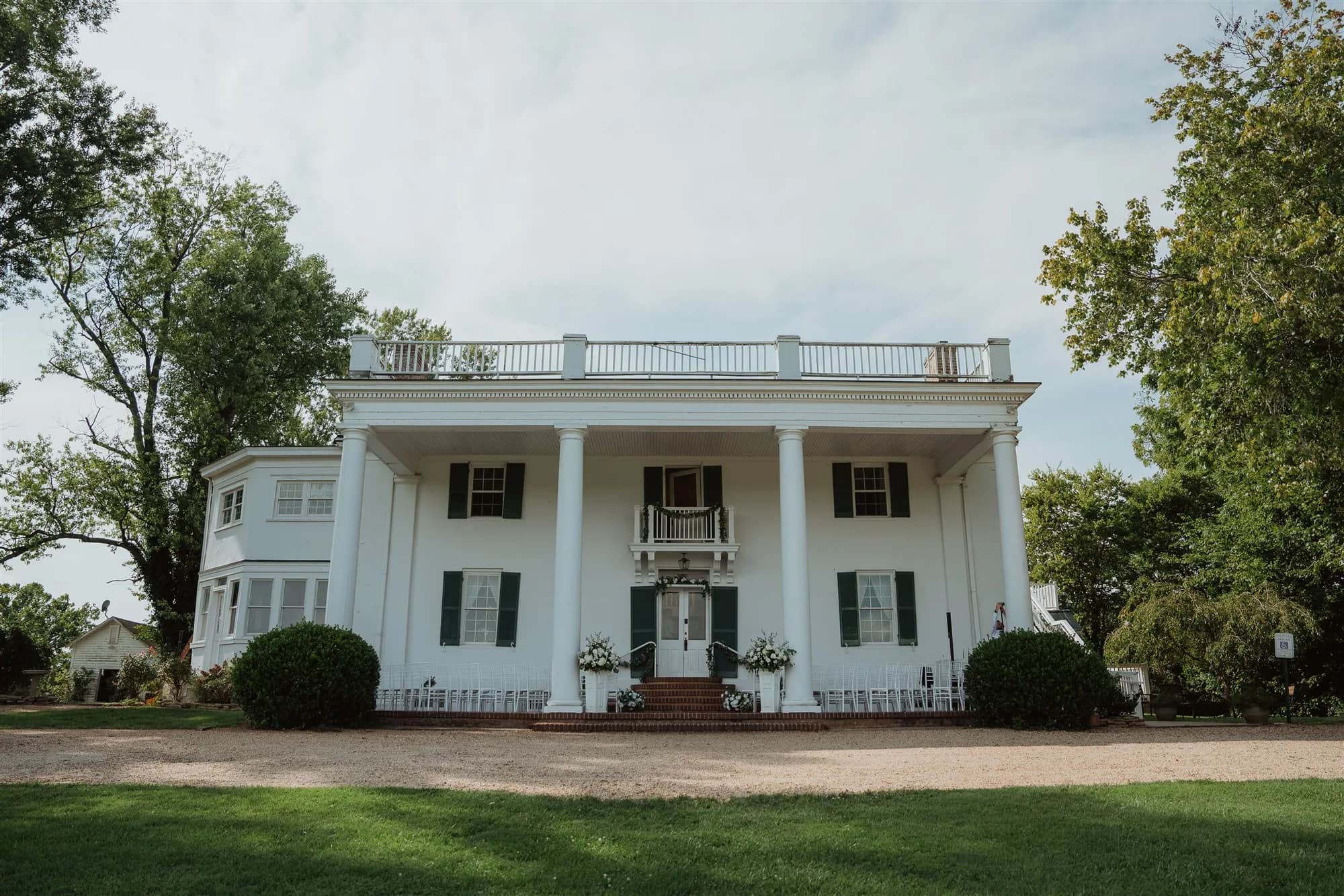 Front facade of Rixey Manor historic white colonial estate with grand columns and brick entry steps