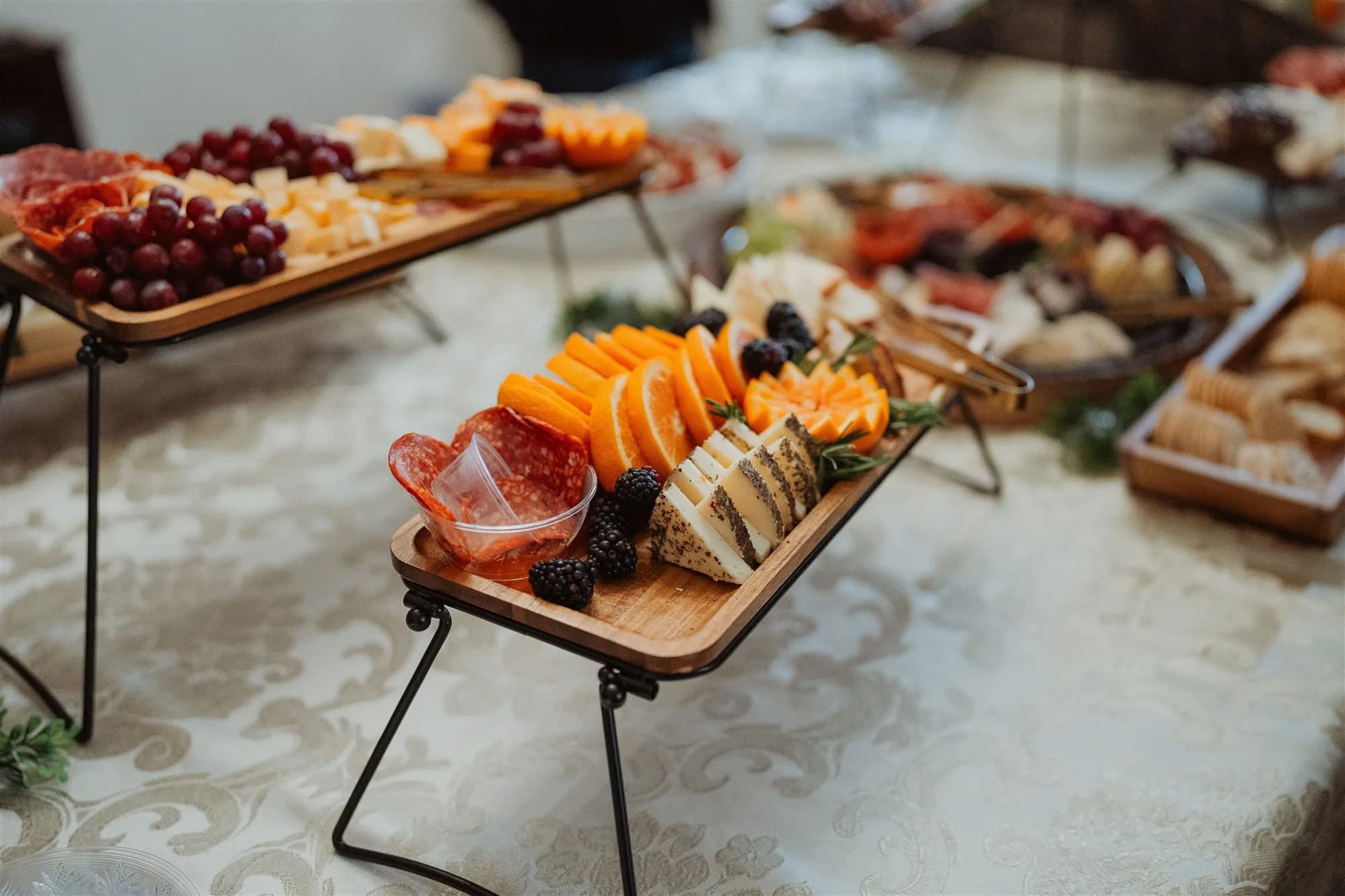 Elegant charcuterie and seafood platters arranged on wooden boards at wedding reception
