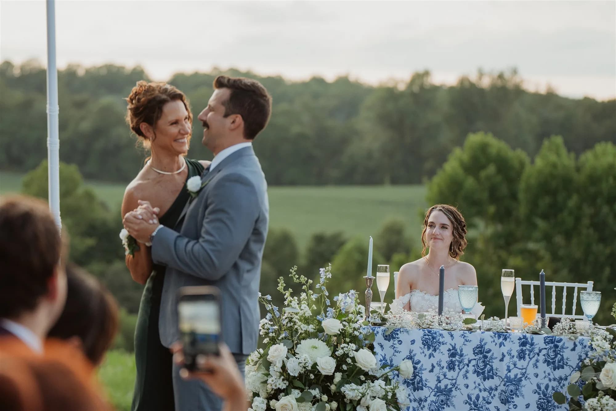 Couple shares a dance at golden hour on Rixey Manor's outdoor terrace with rolling Virginia hills behind them.