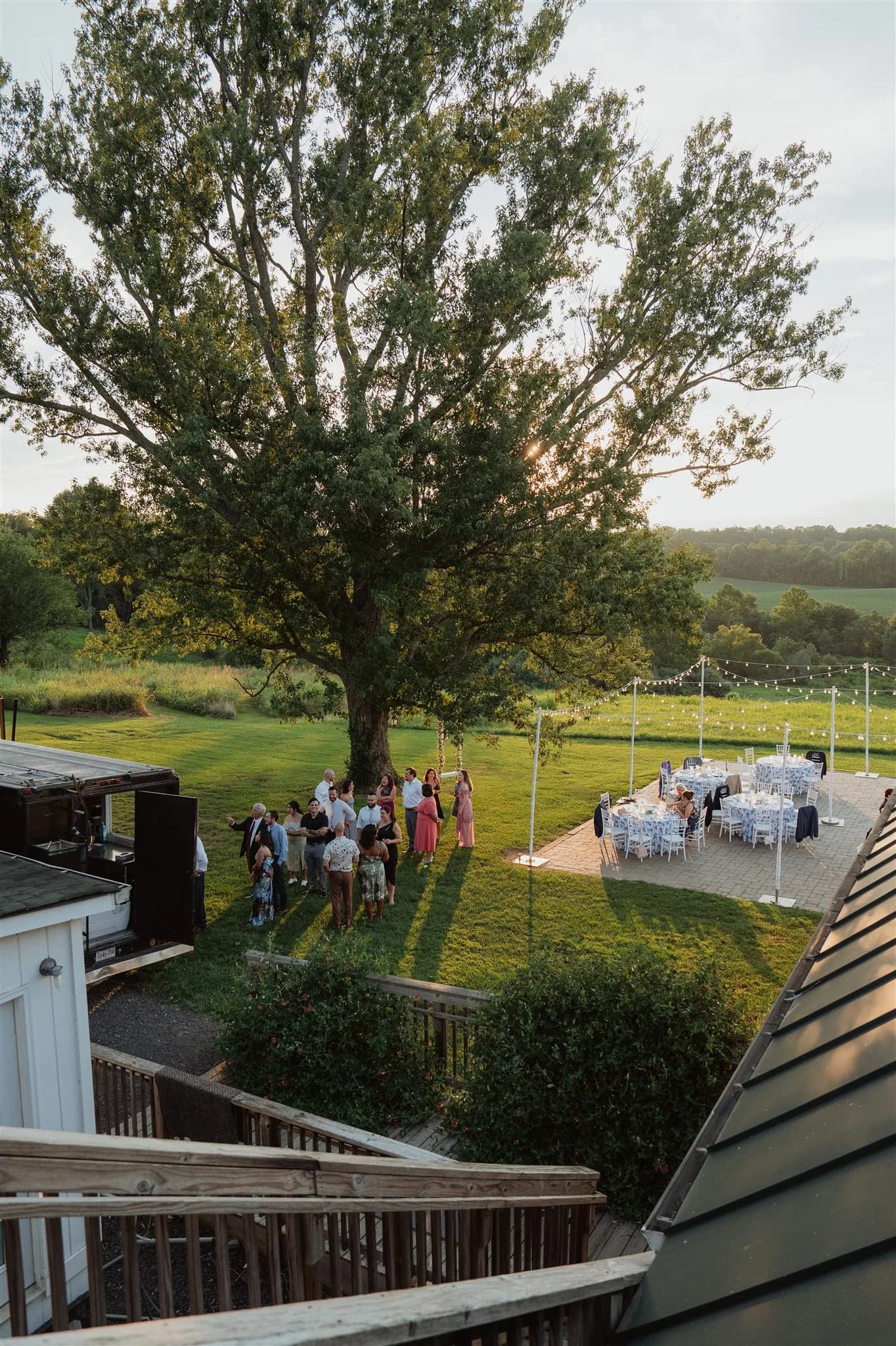 Aerial view of outdoor wedding cocktail hour on Rixey Manor's rolling Virginia countryside at golden hour