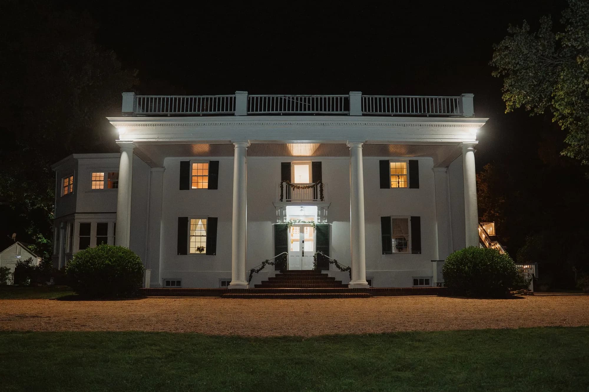 Rixey Manor historic white colonial estate illuminated at night with grand columns and glowing windows