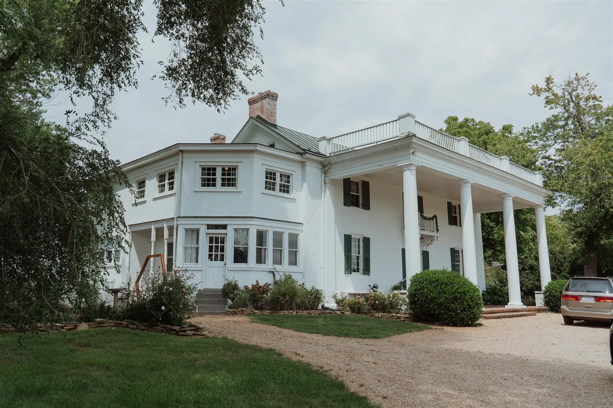 White colonial facade of Rixey Manor with grand columns, rooftop terrace, and lush Virginia grounds