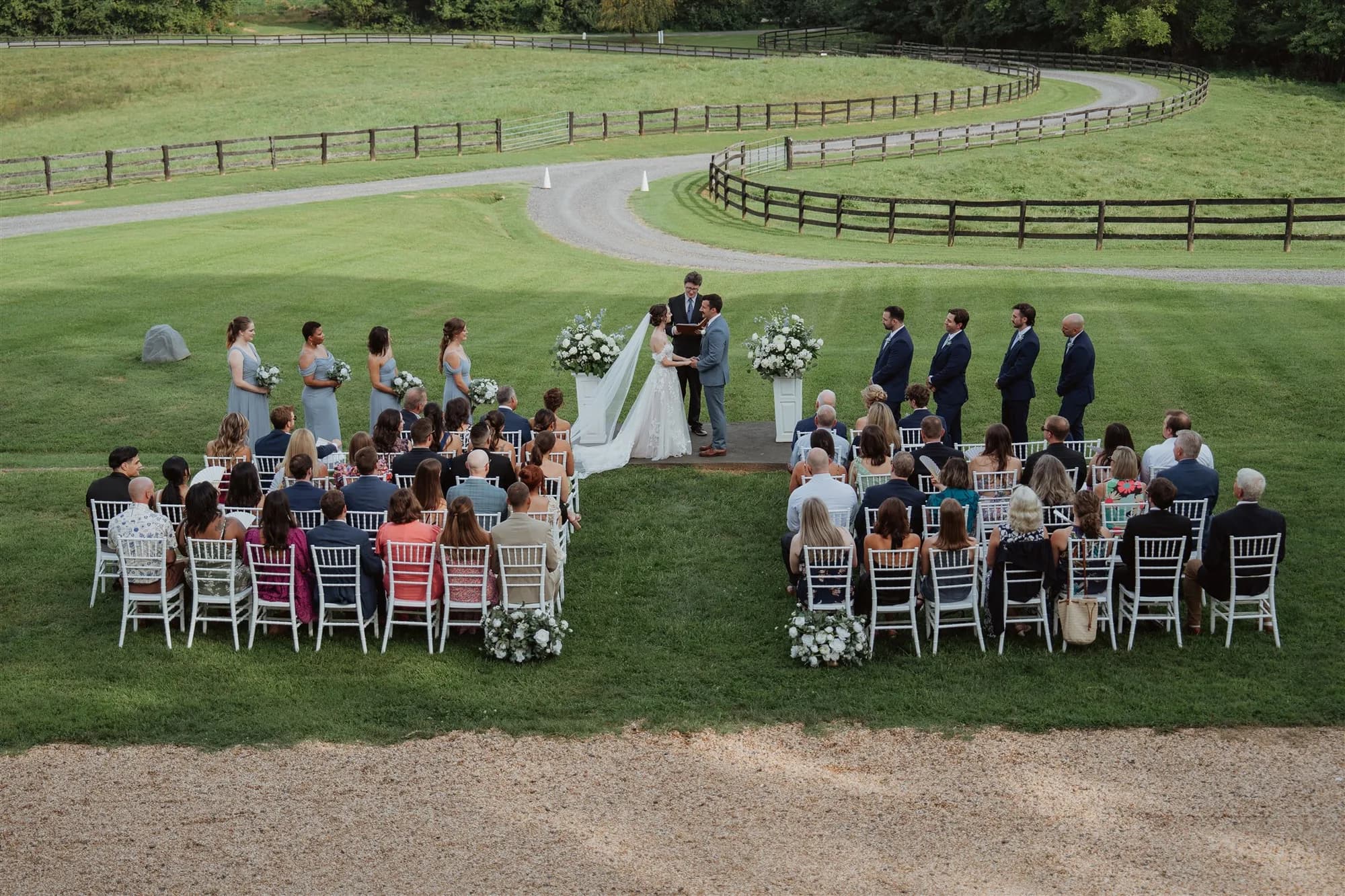 Aerial view of outdoor wedding ceremony on Rixey Manor grounds with guests seated and couple at altar