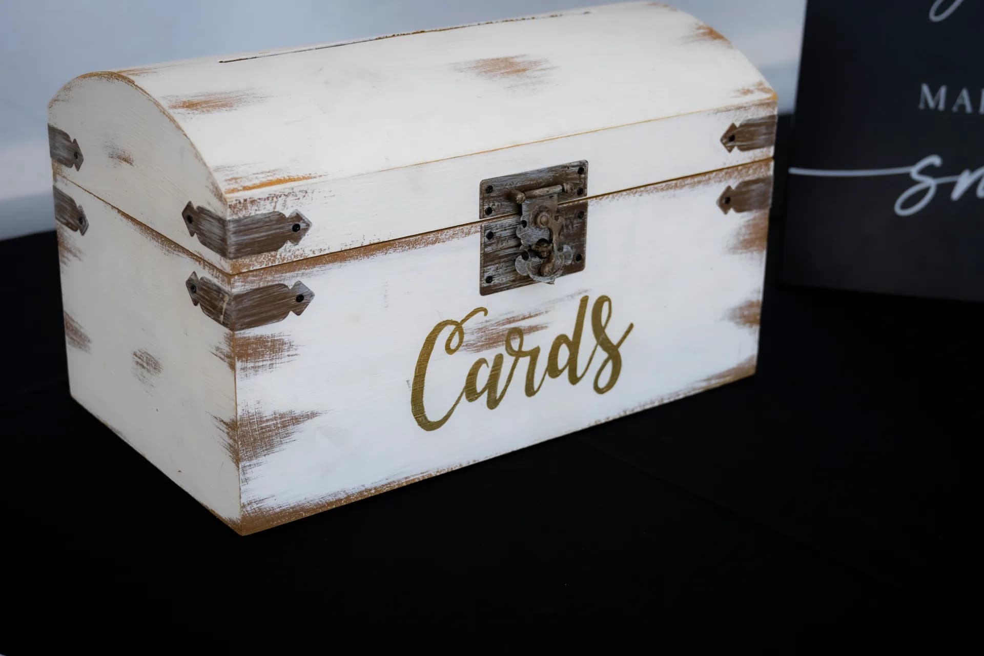 Rustic white distressed wooden wedding card box with gold 'Cards' lettering and metal hardware.