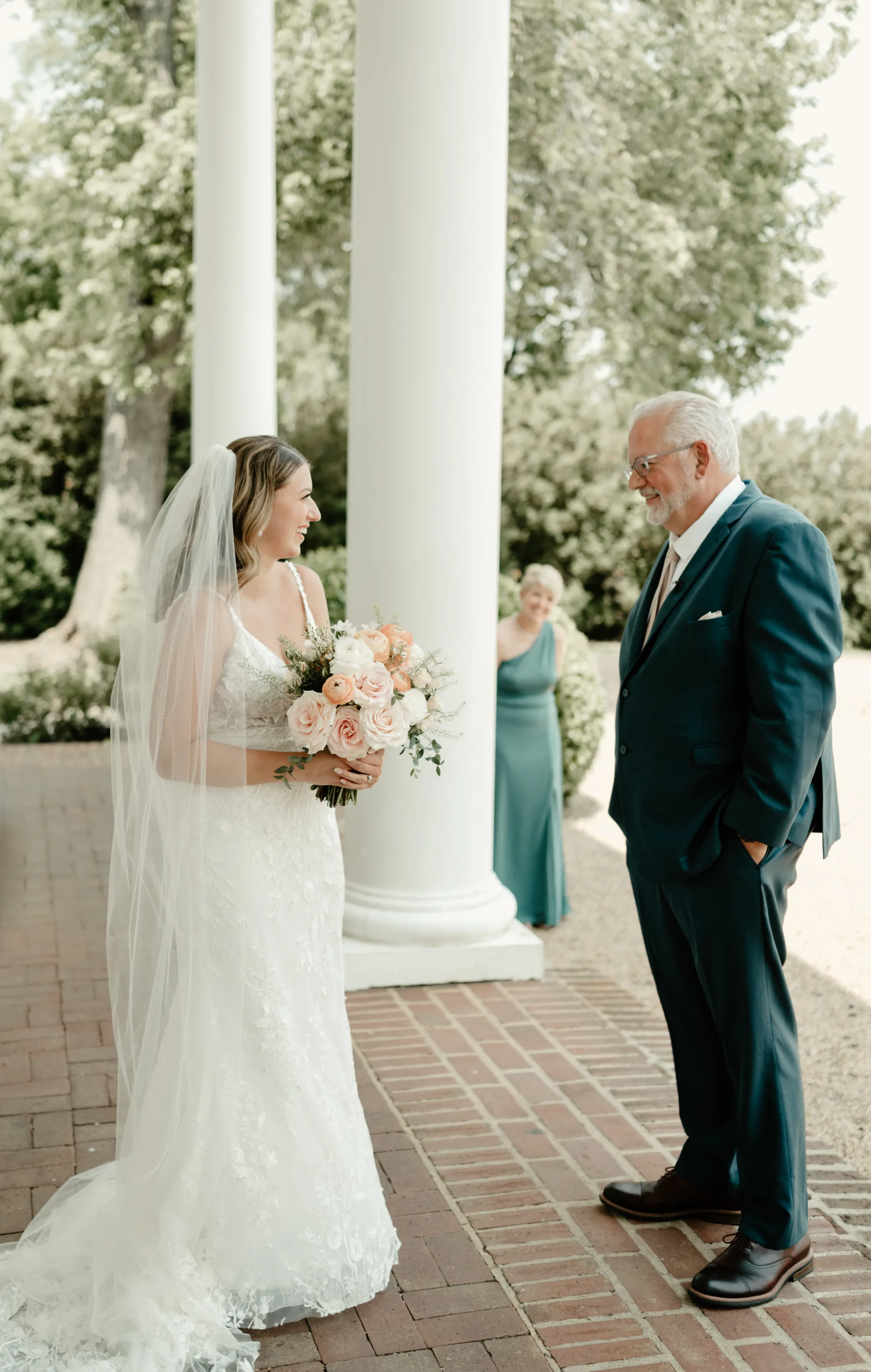 Bride laughing with older man during first look on Rixey Manor's columned portico
