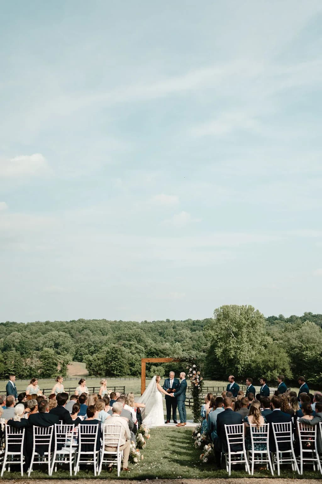 Wide-angle outdoor wedding ceremony at Rixey Manor with guests seated on white chairs overlooking rolling Virginia countryside