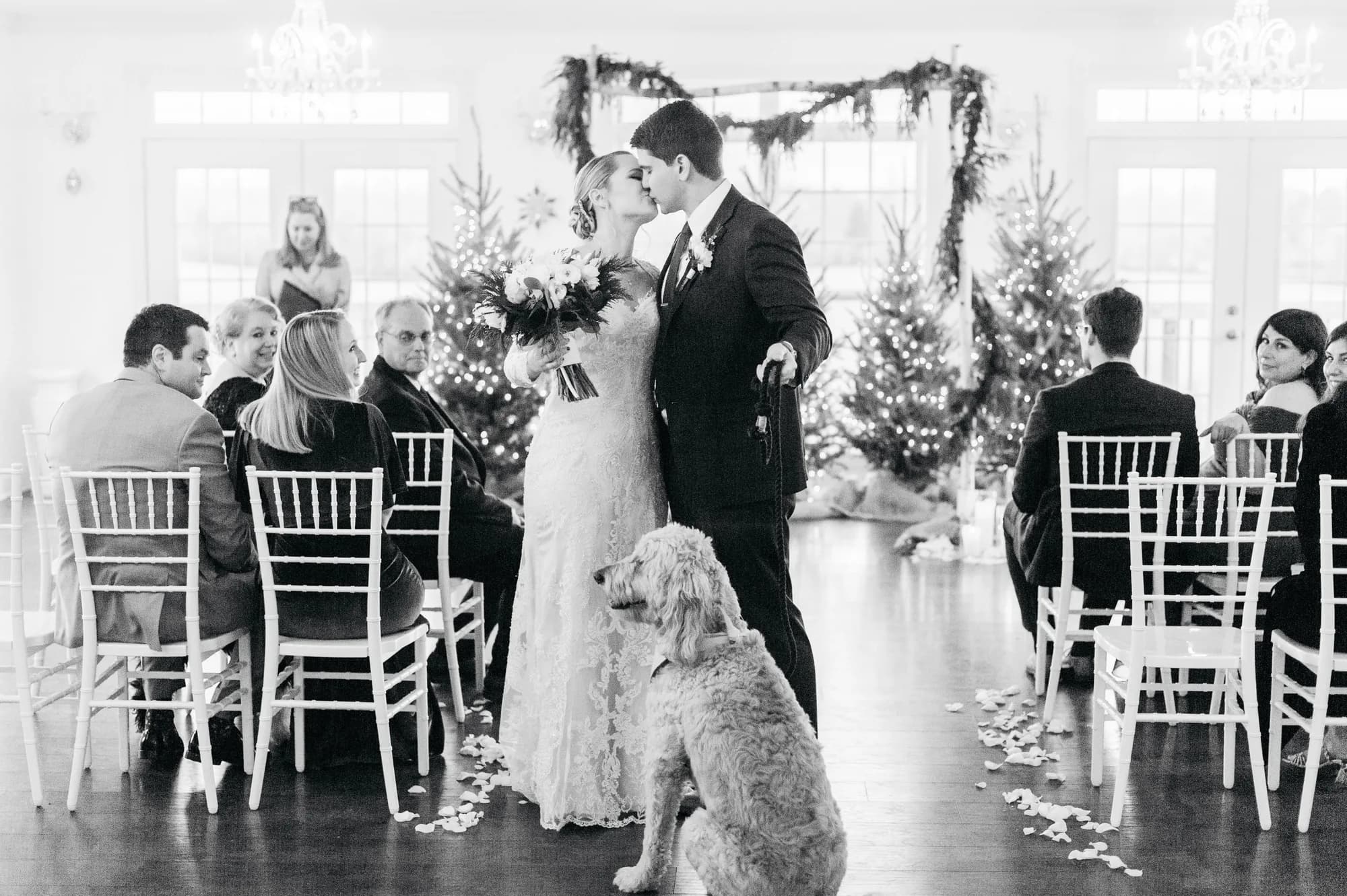 Bride and groom share first kiss at Rixey Manor winter ceremony while their dog watches from the aisle
