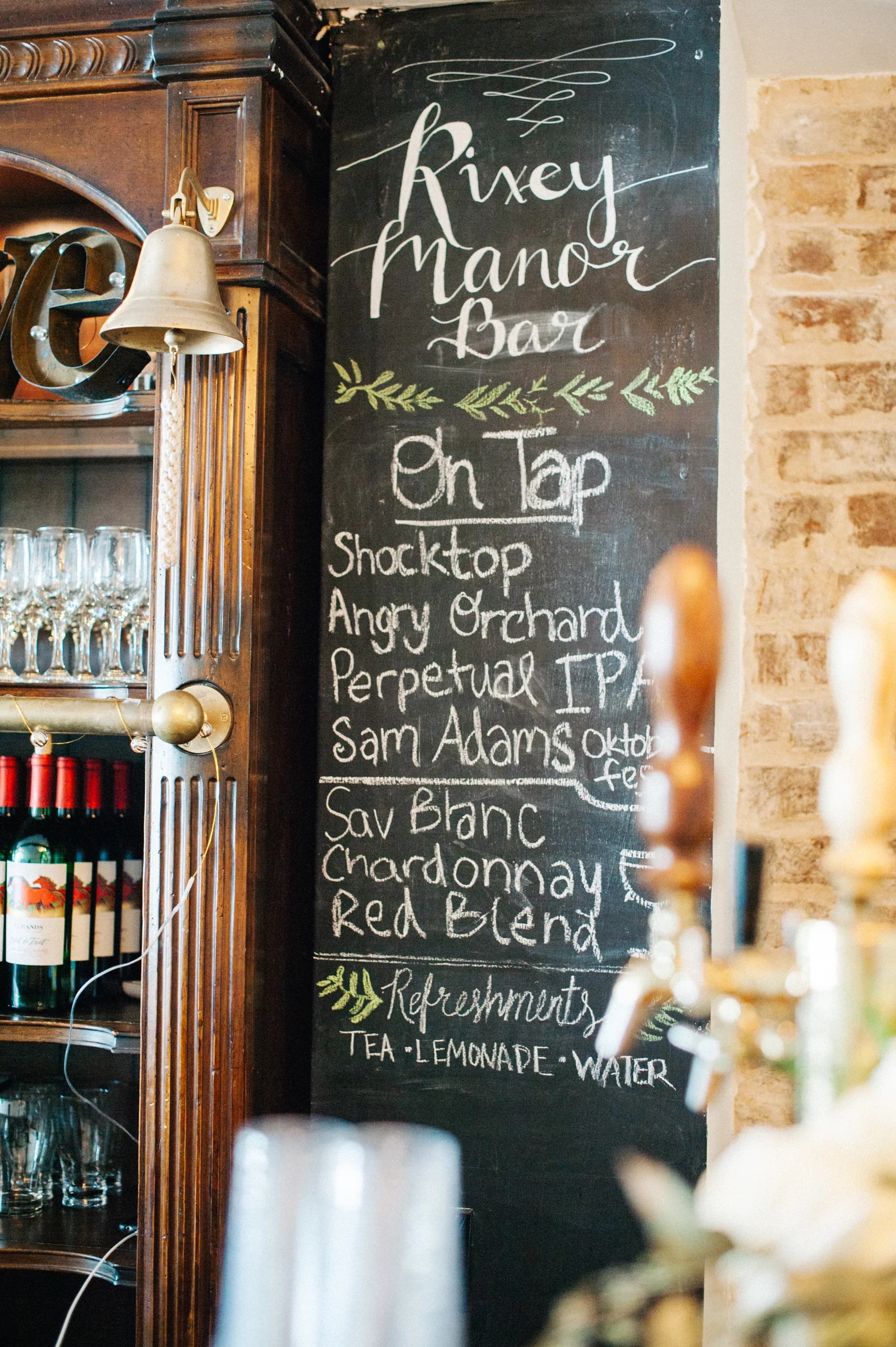 Rixey Manor Bar chalkboard menu with draft beer and wine selections beside a wooden antique cabinet