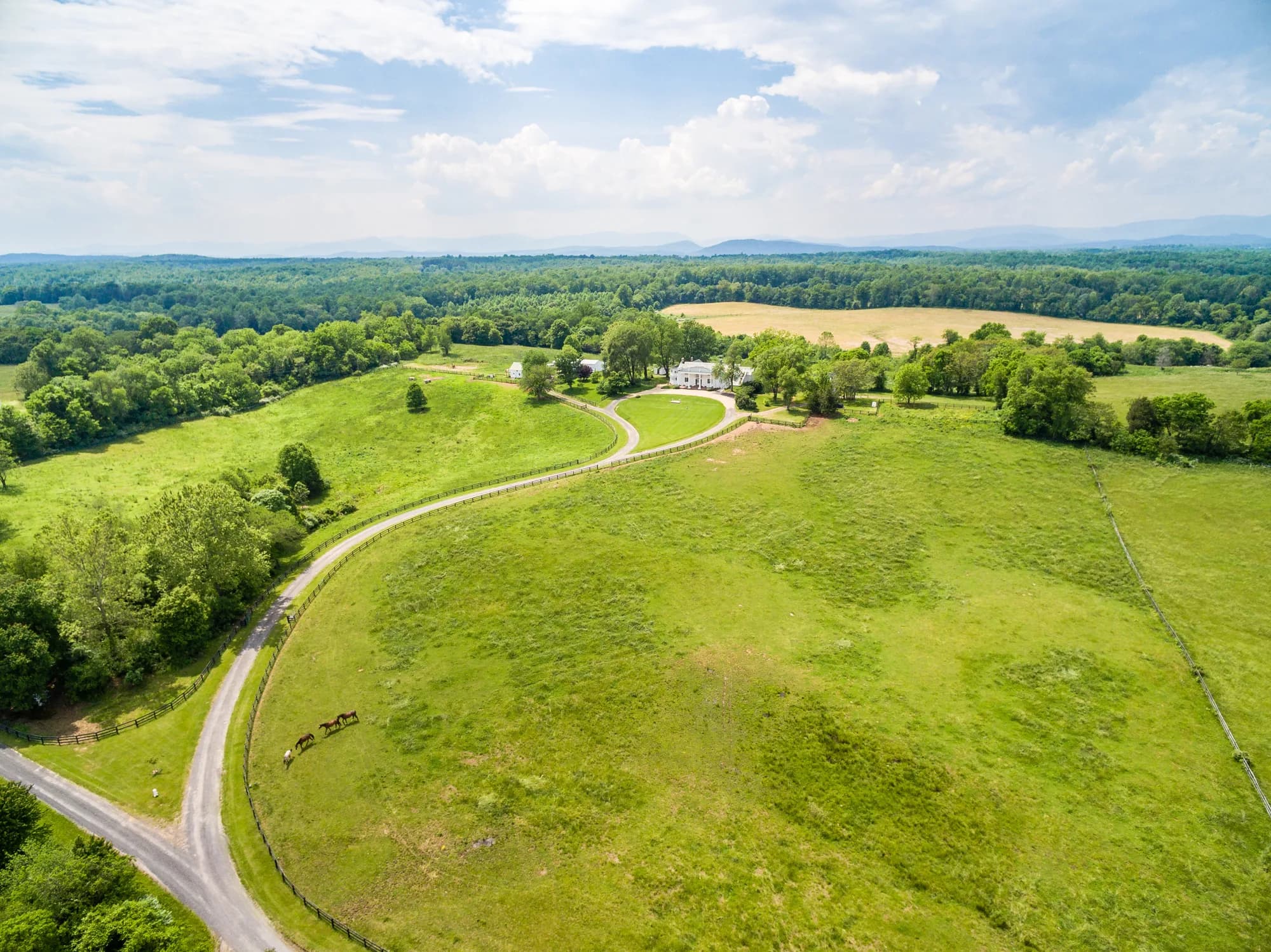 Aerial view of Rixey Manor estate surrounded by rolling green pastures and forest in rural Virginia