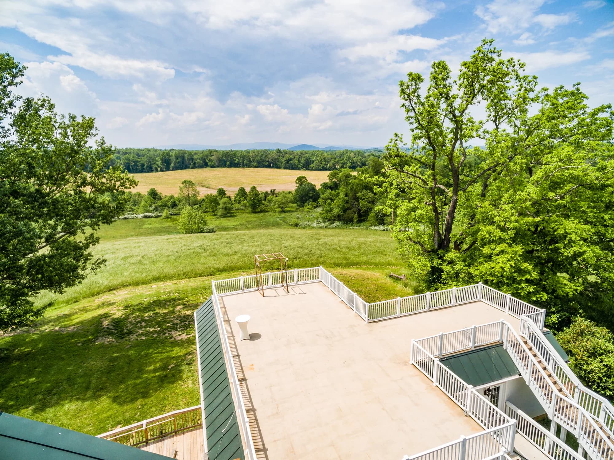 Aerial view of Rixey Manor rooftop terrace overlooking rolling Virginia countryside and Blue Ridge Mountains