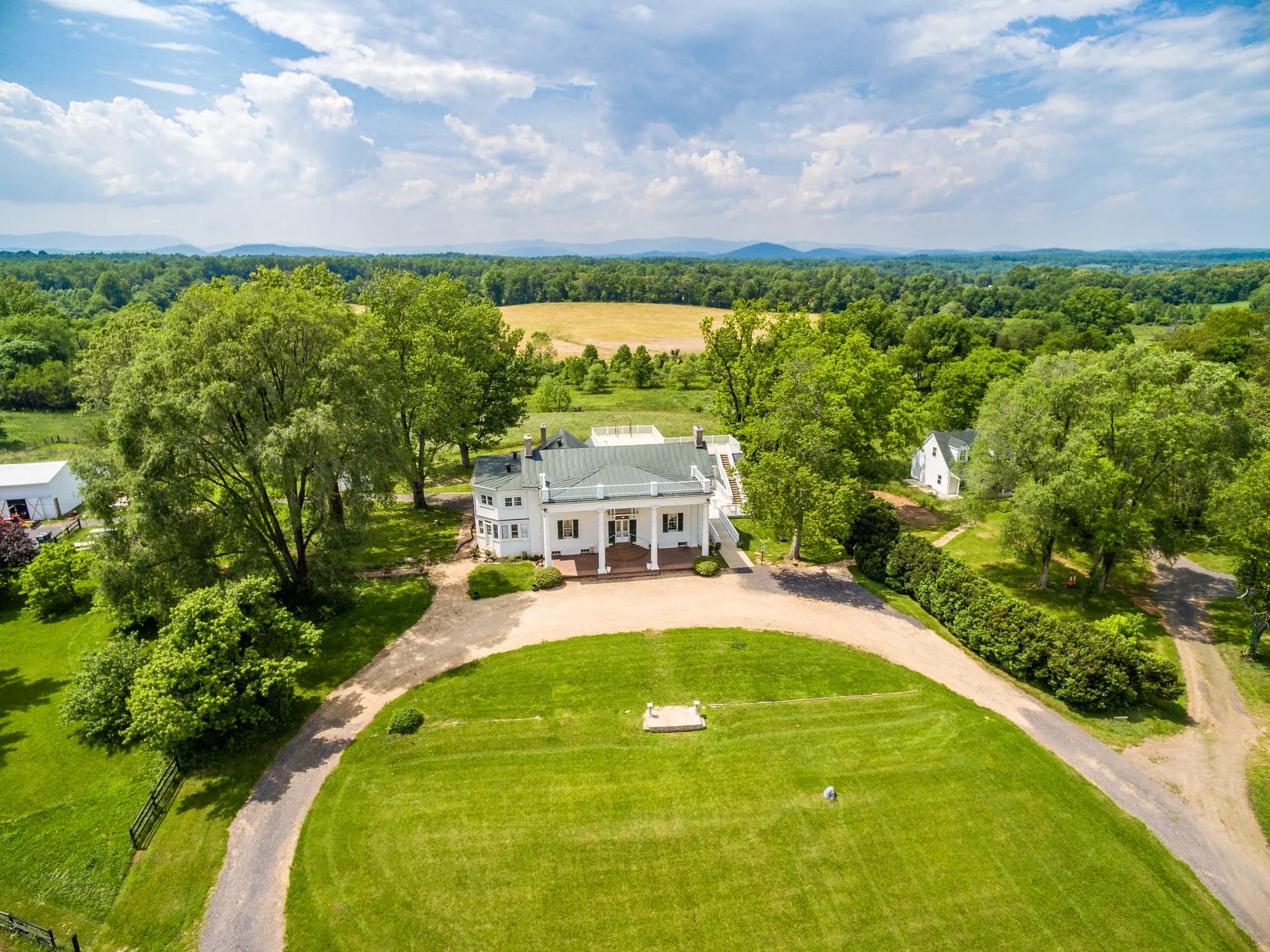 Aerial view of Rixey Manor's white columned estate surrounded by lush Virginia countryside and mountains