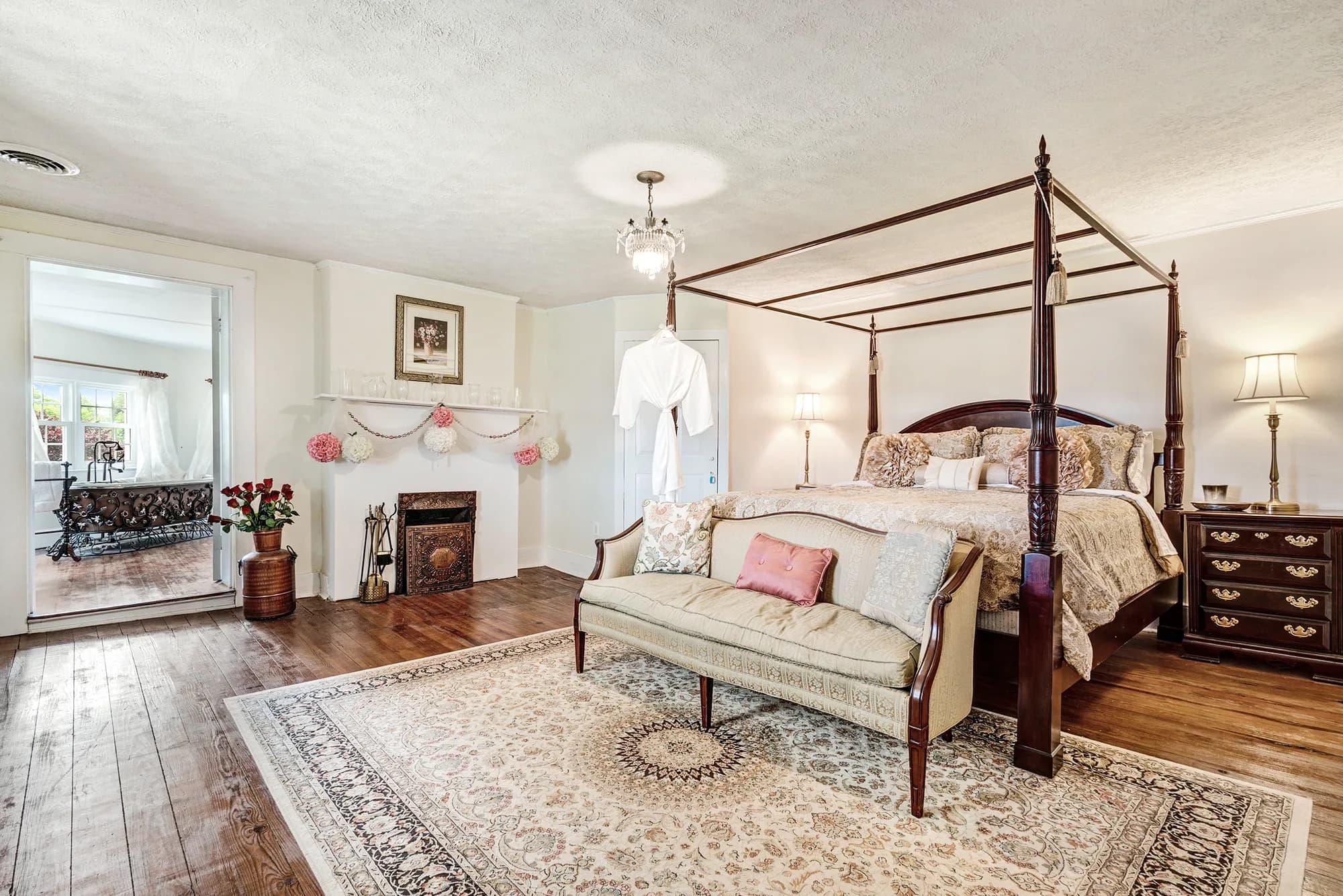 Elegant four-poster bed bridal suite with fireplace and hardwood floors at Rixey Manor