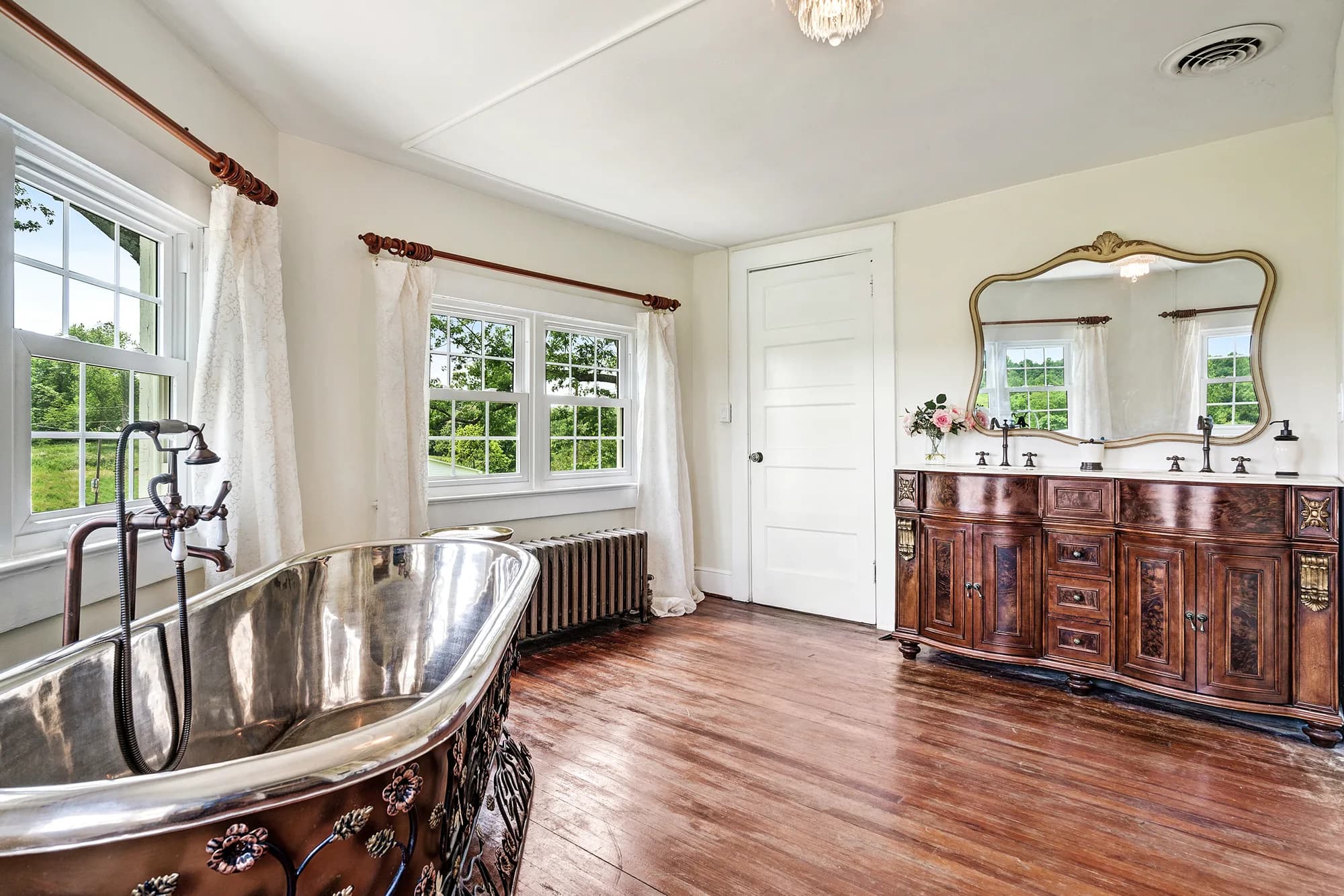 Ornate silver clawfoot tub and antique wood vanity in a bright bridal suite at Rixey Manor